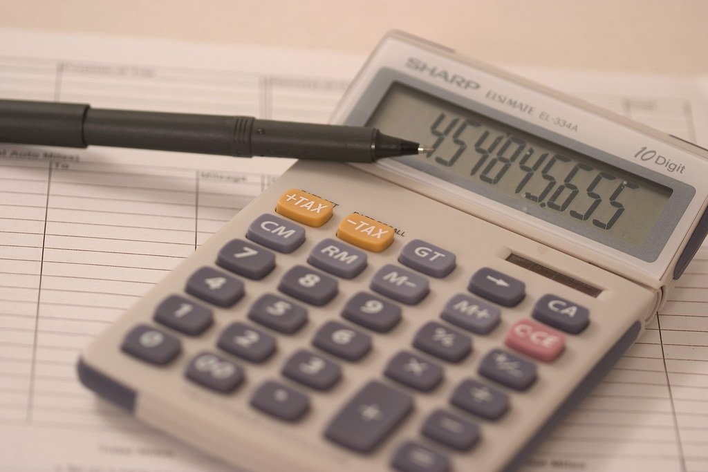 Calculadora, bolígrafo y libro contable - estrategia SEO para asesorias y gestorias