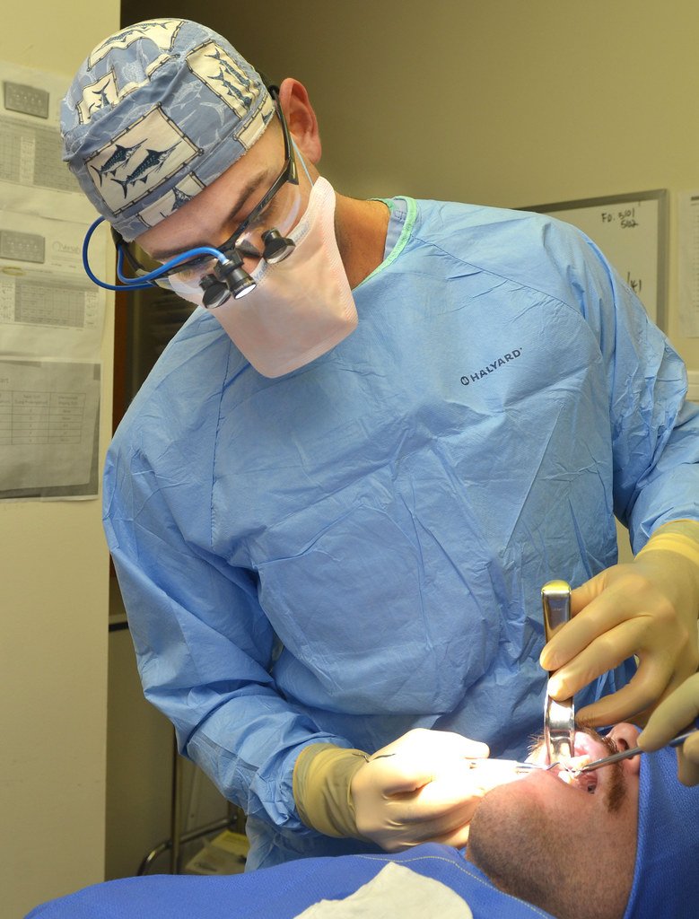 Profesional dental atendiendo a un paciente en clínica dental moderna - estrategia SEO para dentistas