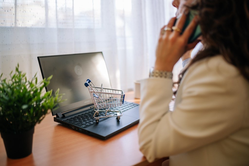 Carrito de compra en un portátil junto a una profesional - decisión entre tienda online o marketplace