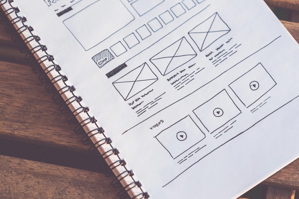 Wireframes de una web corporativa dibujados en papel sobre una mesa de trabajo - errores comunes al rediseñar una web corporativa