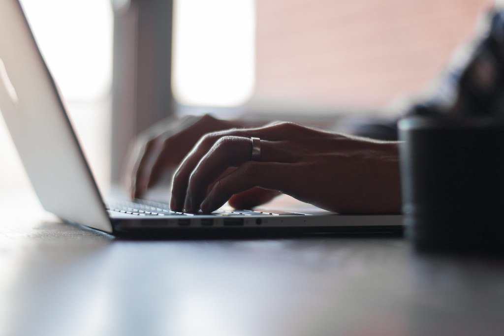 Manos escribiendo en el teclado de un portatil - como redactar textos web que vendan