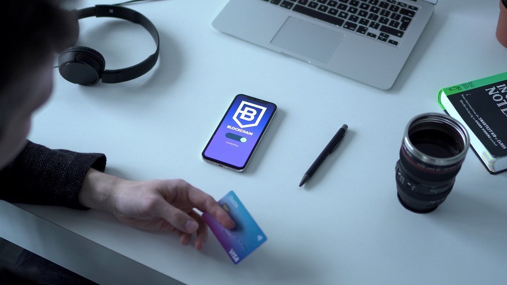 Ordenador portátil, tarjeta de crédito y carrito de compra en escena de ecommerce - reducir abandono del carrito tienda online