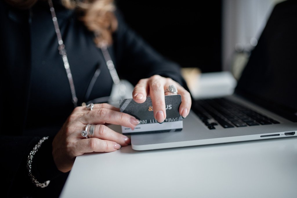 Persona finalizando una compra online con tarjeta en un portatil - estrategia de email marketing para ecommerce