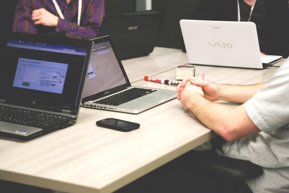 Equipo comercial reunido con portátiles durante una demo de software - Google Ads para empresas SaaS B2B